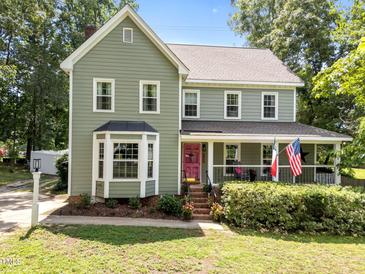 Charming two-story home with green siding, white trim, bay window and a welcoming front porch at 8808 Colesbury Dr, Raleigh, NC 27615