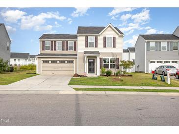 Two-story home featuring a two-car garage and neutral-colored siding, complemented by well-maintained landscaping at 1204 Bridgewater Dr, Durham, NC 27704
