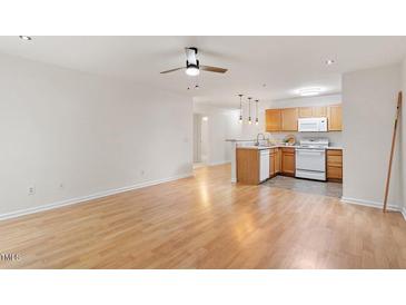 Bright open-concept living area featuring a well-equipped kitchen with modern appliances and a breakfast bar at 1851 Trailwood Heights Ln, Raleigh, NC 27603