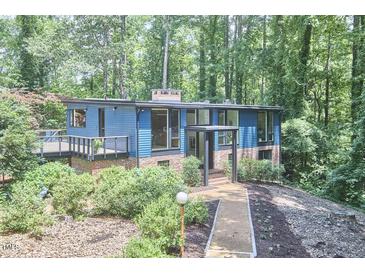 Beautiful two-story home with blue siding, brick accents and large windows in a serene wooded setting at 19 Learned Pl, Durham, NC 27705