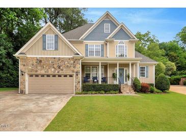 Charming two-story home with stone accents, inviting porch, and well-manicured lawn at 218 Kinvara Ct, Wake Forest, NC 27587