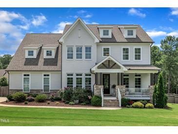 Beautiful two-story home featuring a manicured lawn and a charming covered front porch at 2300 Ginger Gold Court, Apex, NC 27539