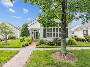 Charming home featuring a well-maintained lawn, lush landscaping and a brick walkway at 31 W Madison, Pittsboro, NC 27312