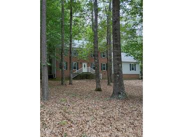 Charming brick home with a welcoming front entrance and lush greenery, perfect for serene living at 3300 Barnsley Ln, Raleigh, NC 27604