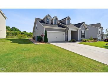Charming two-story home with manicured lawn and a two-car garage on a sunny day at 404 Porterfield Dr, Youngsville, NC 27596