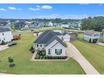 Inviting single-Gathering home boasts lush landscaping, a charming front porch, and an extended driveway in a desirable community at 450 S Parliament Way, Clayton, NC 27520