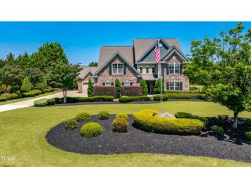 Beautiful two-story home featuring a stone facade, manicured landscaping, and an inviting front yard at 4621 Basilica Dr, Holly Springs, NC 27540
