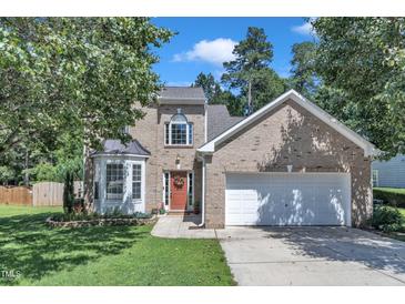 Charming brick two-story home featuring a two-car garage and lush landscaping at 5603 Whisperwood Dr, Durham, NC 27713
