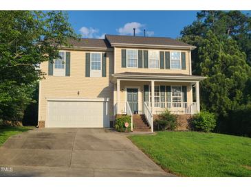 Charming two-story home features a two-car garage, welcoming front porch and a well-maintained lawn at 6701 Winding Arch Dr, Durham, NC 27713