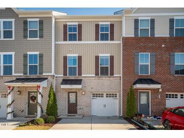 Charming townhome featuring a one-car garage and unique architectural details at 732 Suffield Way, Cary, NC 27519