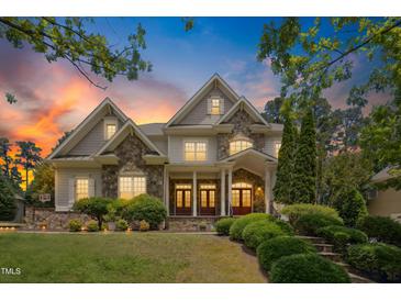 Beautiful two-story home featuring stone accents, manicured landscaping and inviting entrance at sunset at 10909 Grand Journey Ave, Raleigh, NC 27614
