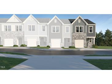 New townhome exterior showcases stone accents, siding, and attached one car garage at 1133 Weavers Trace Dr, Zebulon, NC 27597