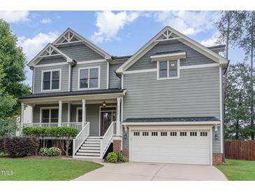 Charming two-story home with a welcoming front porch, manicured lawn and attached two car garage at 1138 Bexley Hills Bnd, Apex, NC 27502
