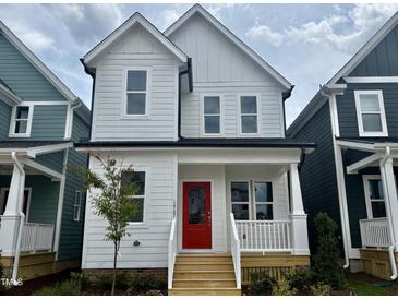 Charming two-story home featuring a bright red front door and a quaint covered porch at 1907 Plott Balsam Dr, Wendell, NC 27591