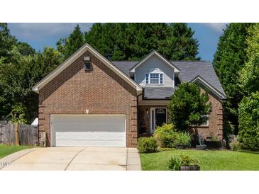 Charming brick home featuring manicured lawn, attached garage, and classic architectural details at 2302 Fordcrest Dr, Apex, NC 27502