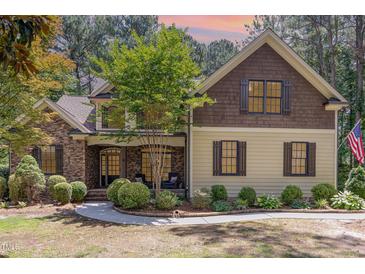 Charming home with stone and siding exterior, manicured lawn, and inviting front porch at 240 Oak Grove Church Rd, Youngsville, NC 27596