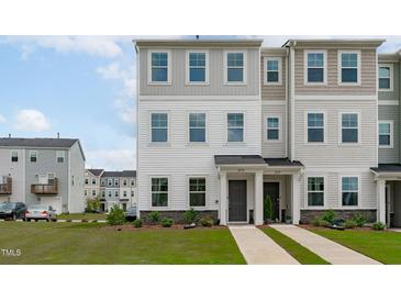Well-maintained two-story townhouse with neutral siding, manicured landscaping, and welcoming front entries at 2539 Kasota Ln, Raleigh, NC 27610