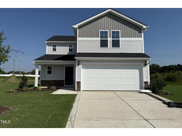 Charming two-story home features a two-car garage, well-maintained lawn, and a classic design at 37 Chloe Ct, Selma, NC 27576