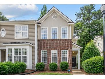 Charming townhome featuring a brick facade and a well-maintained front yard with lush greenery at 4413 Sugarbend Way, Raleigh, NC 27606