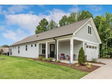 Charming single-story home boasts a manicured lawn, gray siding, and a cozy front porch at 8217 White Star Dr, Fuquay Varina, NC 27526