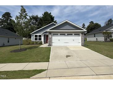 Beautiful exterior view of a single-Gathering home, showcasing a well-manicured lawn and a two-car garage at 8680 Kenridge Ln, Fuquay Varina, NC 27526