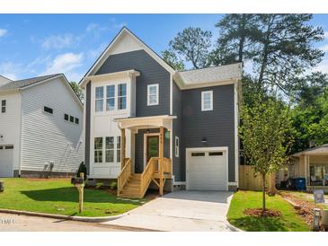Charming two-story home with a gray exterior, white trim, covered porch, and well-manicured lawn at 905 Deboy St, Raleigh, NC 27606