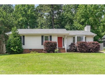 Charming single-story home with a well-maintained lawn, red front door and manicured shrubbery at 9709 Batesville Dr, Raleigh, NC 27617