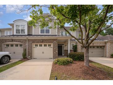 Charming townhome with a brick and siding exterior, two-car garage, and well-maintained landscaping at 1016 Kingston Grove Dr, Cary, NC 27519