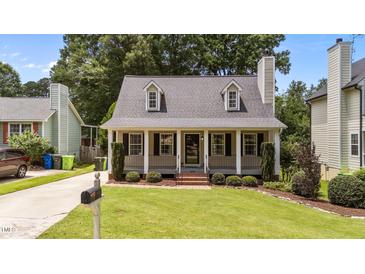 Charming home featuring a beautifully landscaped front yard, dormer windows and inviting porch with black shutters at 1033 Mills St, Raleigh, NC 27608