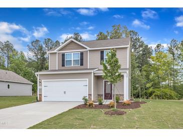 Charming two-story home with a well-manicured lawn, inviting entrance, and attached two-car garage at 106 Flue Ct, Oxford, NC 27565