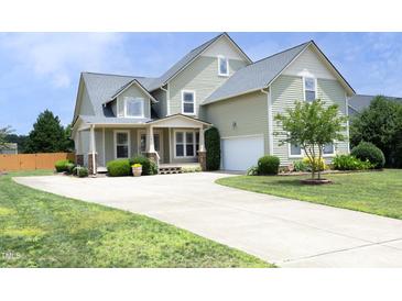Two-story home with a well-manicured lawn, large driveway, and attached garage at 25 Ruth Cir, Fuquay Varina, NC 27526