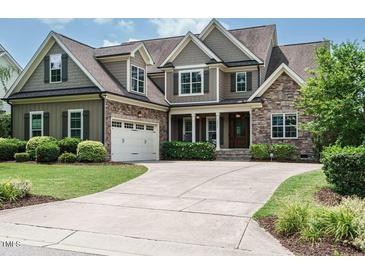 Charming two-story home with stone and shingle accents and a well-manicured lawn at 3021 Lawson Walk Way, Rolesville, NC 27571