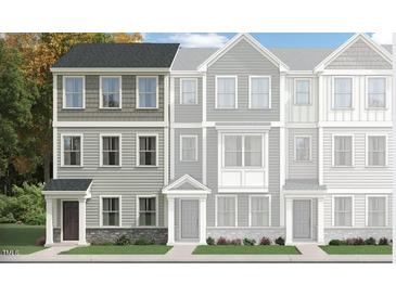 Charming townhome showcasing a stylish three-story design with varied siding and a welcoming front entrance at 324 Carolina Springs Blvd, Apex, NC 27539