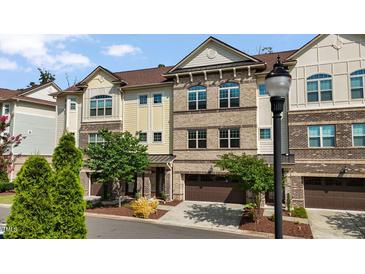 Charming brick and siding townhome with an attached garage and manicured landscaping, inviting curb appeal at 341 View Dr, Morrisville, NC 27560