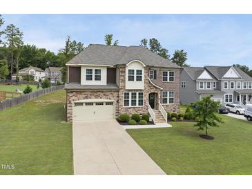 Beautiful two-story home featuring a manicured lawn and a large driveway leading to a two-car garage at 433 Village Bend Dr, Fuquay Varina, NC 27526
