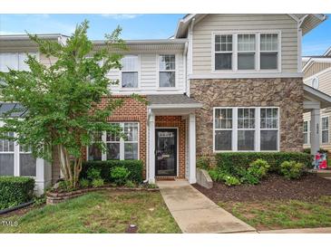 Charming townhome featuring a blend of brick and stone facade with manicured landscaping at 4826 Sir Duncan Way, Raleigh, NC 27612