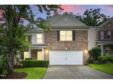 Charming brick home with a two-car garage and a well-manicured front yard at 518 Emerald Downs Rd, Cary, NC 27519