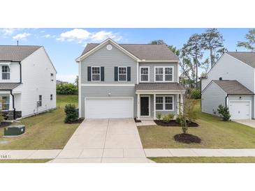 Charming two-story home with gray siding, attached garage and well-maintained lawn in a suburban neighborhood at 908 Adelphia Rd, Fuquay Varina, NC 27526
