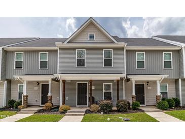 Charming townhouse with a covered front porch and well-maintained landscaping, showcasing curb appeal at 121 Longleaf Pine St, Clayton, NC 27527