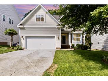 Charming beige two-story home featuring an attached garage and well-manicured lawn at 1304 Trailing Rose Ct, Wake Forest, NC 27587