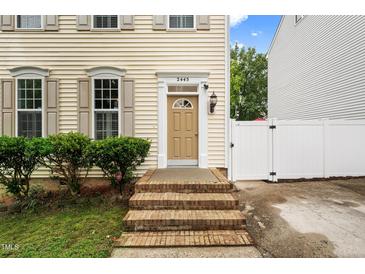 Inviting entrance with brick steps, tan door, and stylish shutters at this charming home at 2445 Sapphire Valley Dr, Raleigh, NC 27604