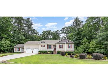 Charming two-story home featuring a well-manicured lawn, an attached two car garage and mature landscaping at 281 Kinsman Ct, Fuquay Varina, NC 27526