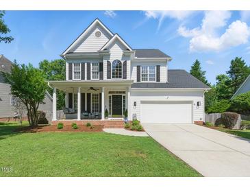 Charming two-story home with a well-manicured lawn, inviting porch swing, and attached two-car garage at 2933 Creek Moss Ave, Wake Forest, NC 27587