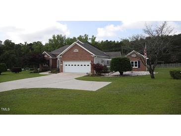 Charming brick home features a well-manicured lawn and attached two-car garage at 3409 Bennyfield Ct, Fuquay Varina, NC 27526