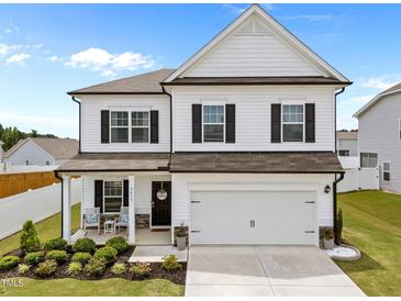 Charming two-story home featuring a two-car garage, inviting front porch, and manicured landscaping at 3613 Cross Timber Ln, Raleigh, NC 27603