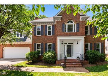 Charming brick home with a well-manicured lawn, gray shutters and a welcoming front entrance at 3720 Bridgeton Park Dr, Raleigh, NC 27612