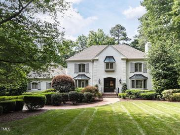 Elegant white brick home showcasing manicured landscaping and inviting curb appeal at 5005 Lenoraway Dr, Raleigh, NC 27613
