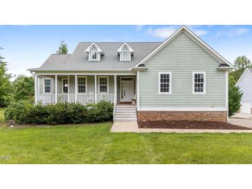 Charming home featuring a welcoming front porch and a beautifully maintained lawn at 100 Virginia Lee Ln, Efland, NC 27243