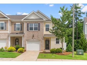 Charming townhouse featuring a brick and siding facade, one-car garage and well-manicured landscaping at 1007 Epiphany Rd, Morrisville, NC 27560