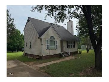 Traditional home with a chimney, vinyl siding, and a well-maintained lawn, offering comfort and charm at 101 New Castle Ct, Youngsville, NC 27596